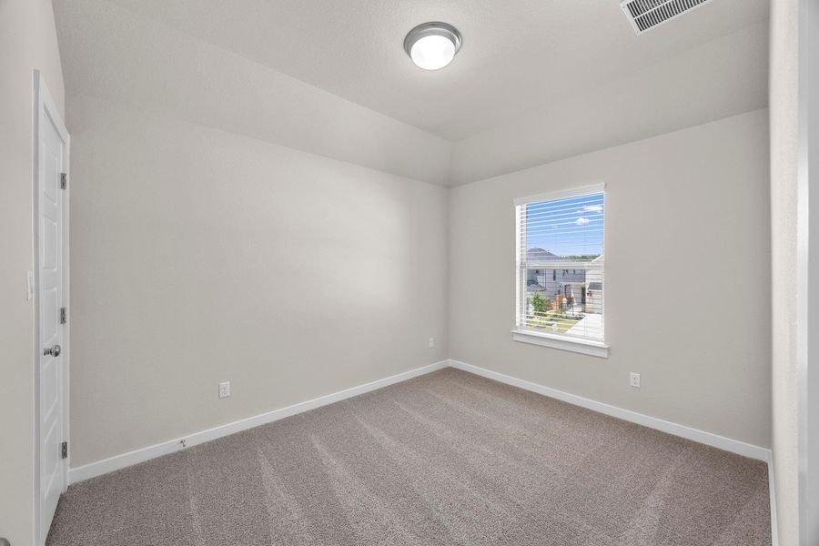 A well-lit bedroom features plush carpeting and a bright window overlooking the neighborhood. A well-lit bedroom features plush carpeting and a bright window overlooking the neighborhood.
