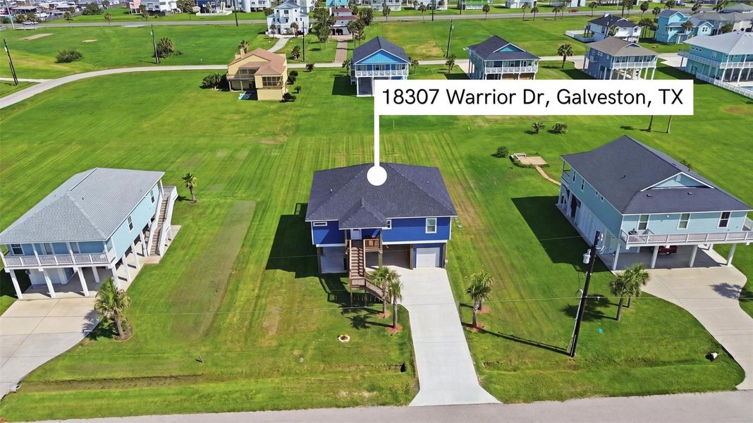 Charming coastal home in Galveston, TX, featuring elevated design, lush green lawn, and surrounded by other picturesque properties. Charming coastal home in Galveston, TX, featuring elevated design, lush green lawn, and surrounded by other picturesque properties.