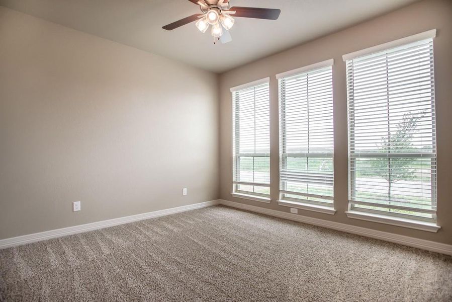 Spare room with baseboards, light carpet, and a ceiling fan