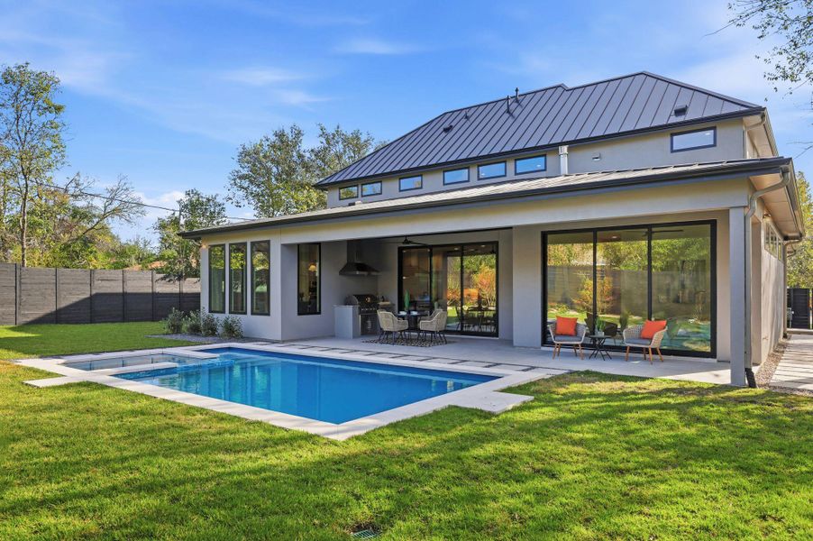 Rear view of property featuring a patio, ceiling fan, stucco siding, a pool with connected hot tub, and outdoor dining area Rear view of property featuring a patio, ceiling fan, stucco siding, a pool with connected hot tub, and outdoor dining area