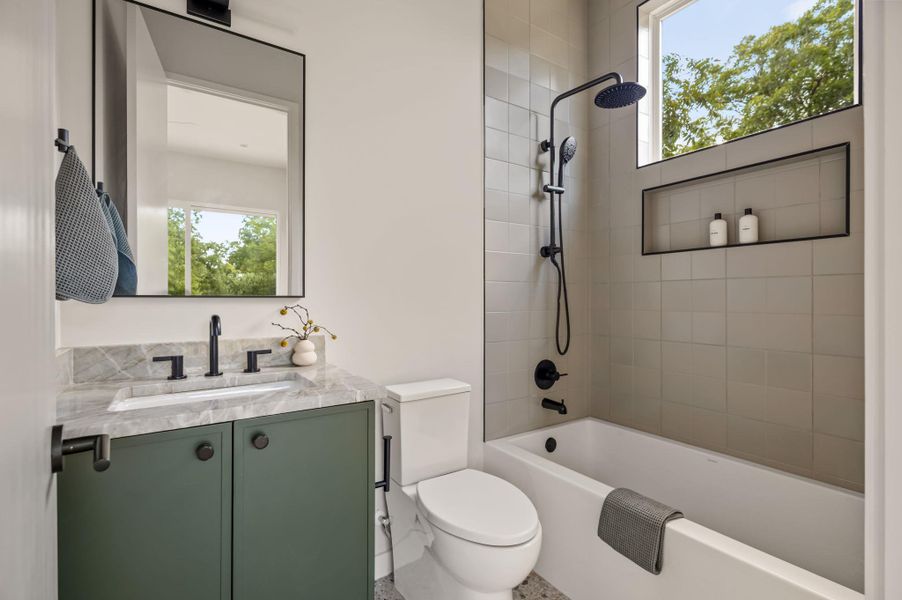 A modern bathroom features a tiled shower surround, stone-countertop vanity, and clean architectural lines. A modern bathroom features a tiled shower surround, stone-countertop vanity, and clean architectural lines.
