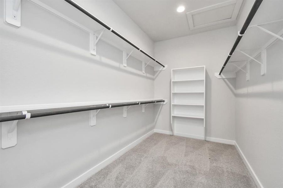 Immerse yourself in the lap of luxury within this roomy walk-in closet boasting high ceilings and plush carpeting. Sample photo of completed home with similar floor plan. As-built interior colors and selections may vary.