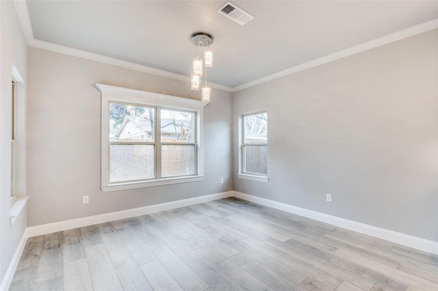 Unfurnished room featuring ornamental molding and light wood-type flooring