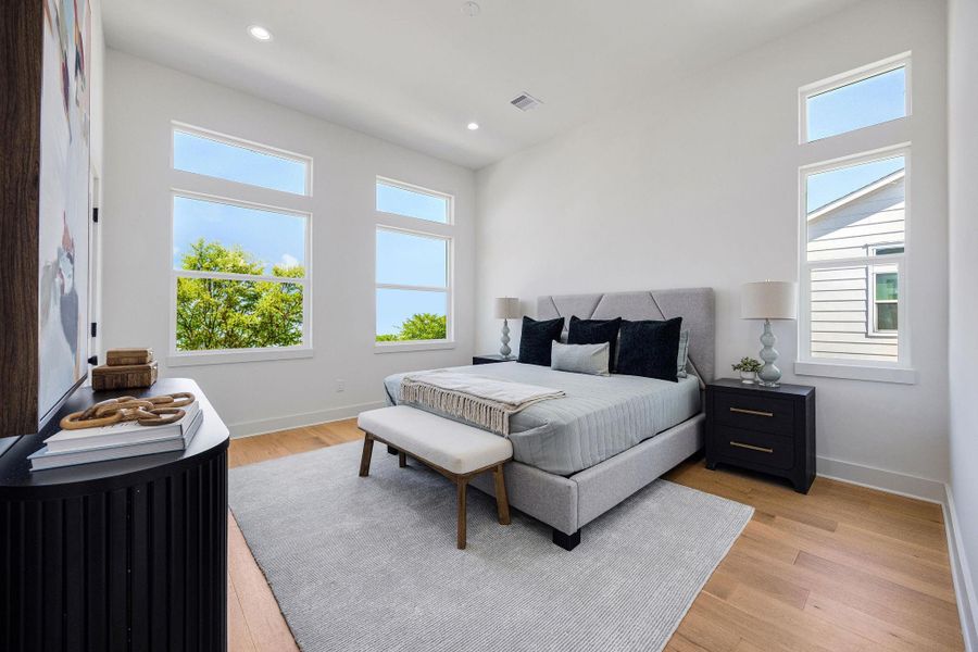 Spacious primary bedroom flooded with lots of natural light, located on the third floor.