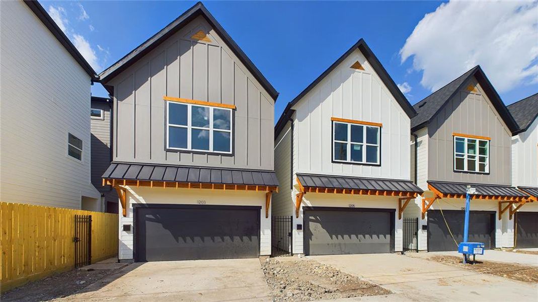 With a perfect balance of traditional and contemporary design, this 2-story farmhouse blends different patterns of Hardie siding with lightly-stained treated wood.