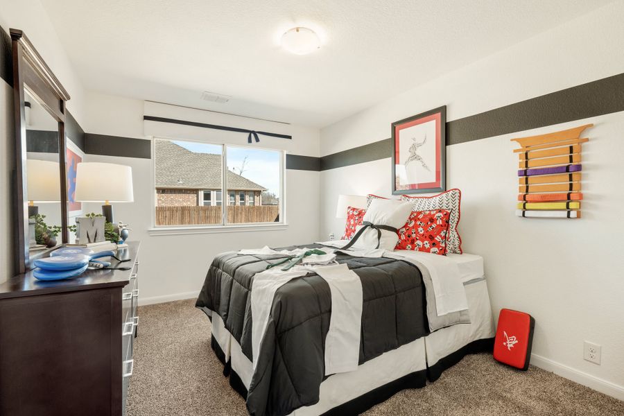 Children's bedroom with gray and white striped walls, carpet flooring, and martial arts themed decor