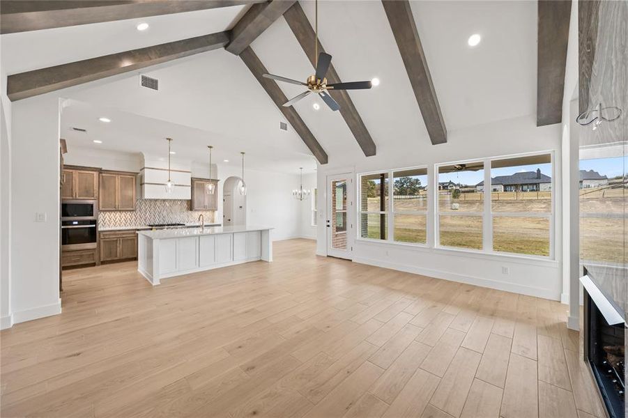 Vaulted ceiling featuring exposed wood beams and a contemporary ceiling fan