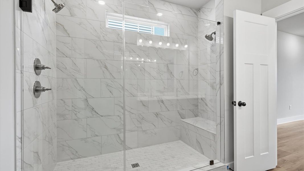 Accomplished design shines in this primary bath with dual vanity and a sleek walk-in shower at Harrier Point Accomplished design shines in this primary bath with dual vanity and a sleek walk-in shower at Harrier Point