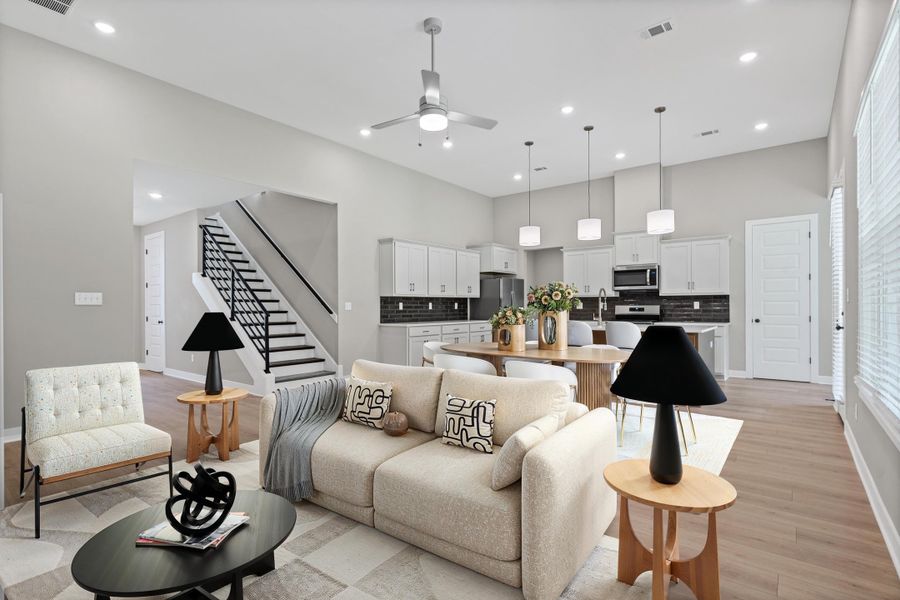 Open-concept living space featuring wood-finish flooring, recessed lighting, and a contemporary ceiling fan Open-concept living space featuring wood-finish flooring, recessed lighting, and a contemporary ceiling fan