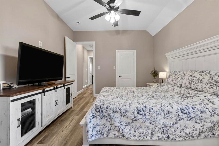 Bedroom with hardwood / wood-style flooring, ceiling fan, and lofted ceiling