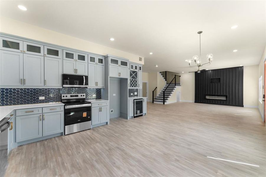 Kitchen featuring appliances with stainless steel finishes, recessed lighting, a chandelier, decorative backsplash, and light countertops