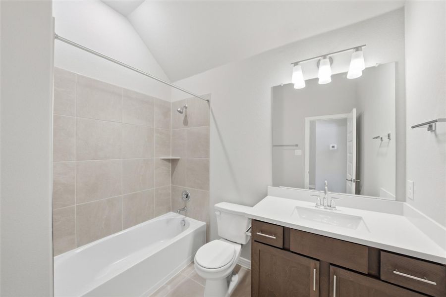 Full bathroom with washtub / shower combination, vanity, light tile patterned flooring, and lofted ceiling Full bathroom with washtub / shower combination, vanity, light tile patterned flooring, and lofted ceiling