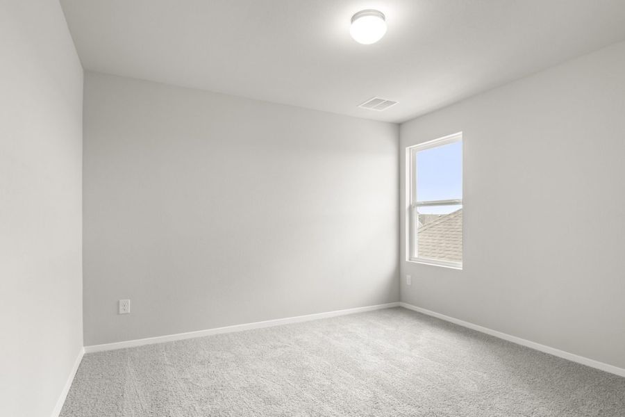 Image of bedroom with light grey walls and carpet with a window