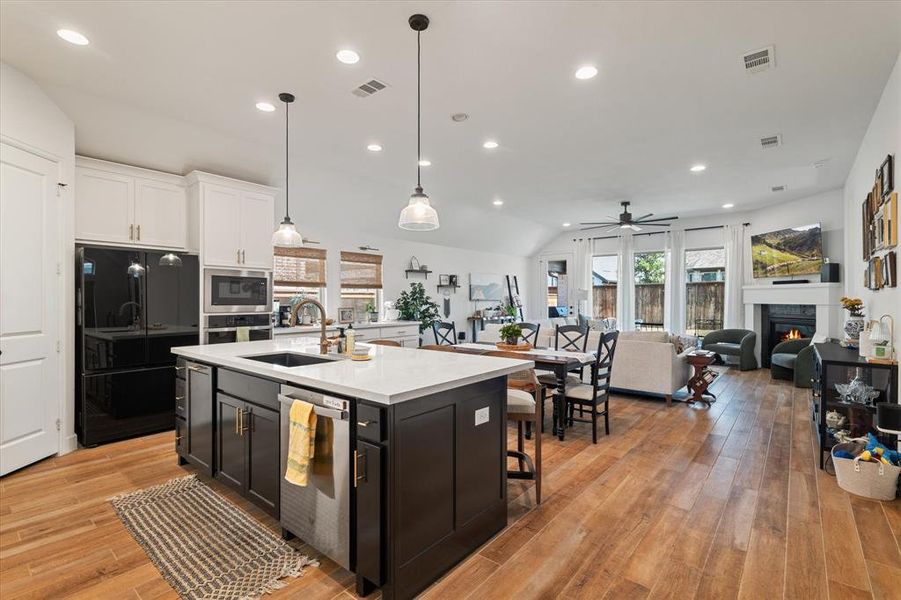 Kitchen with lofted ceiling, white cabinetry, recessed lighting, light countertops, and stainless steel appliances Kitchen with lofted ceiling, white cabinetry, recessed lighting, light countertops, and stainless steel appliances