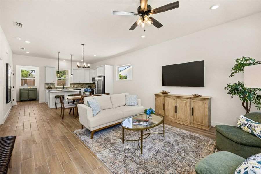 An open-concept living space integrates a well-appointed kitchen and comfortable lounge area, all bathed in natural light.