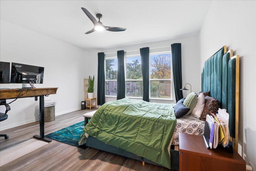 Bedroom featuring wood finished floors, a ceiling fan, and a desk