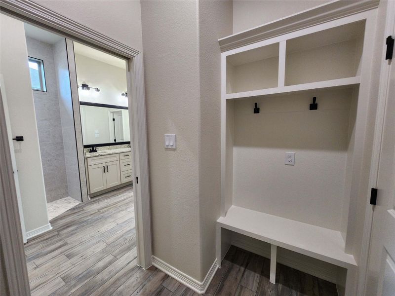 Built-in white storage bench with upper shelving and integrated hooks