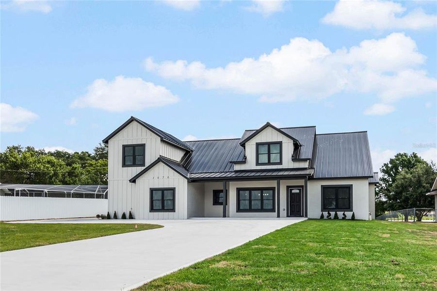 This exquisite modern farmhouse in Lake Ariana, Florida, spans a generous 3,505 square feet, blending classic charm with contemporary flair.It features a gorgeous, wide driveway that sweeps elegantly to an attached multi-car garage, offering plenty of room for vehicles and storage. Set against a beautifully manicured lawn, this home provides a serene retreat with a blend of luxury and practical design, perfect for both relaxing and entertaining.