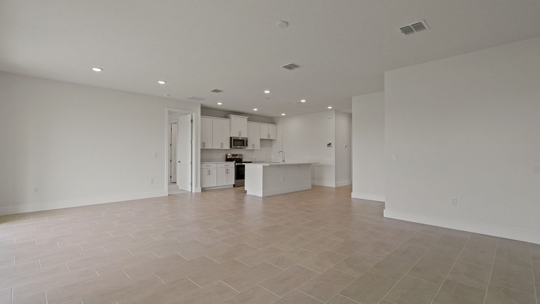 Living Area and Kitchen in the Buttonwood floorplan by DRB Homes at Lakeside at Satilla in Saint Cloud, FL