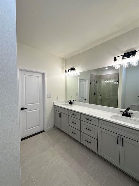 Bathroom featuring tile patterned floors, vanity, and an enclosed shower