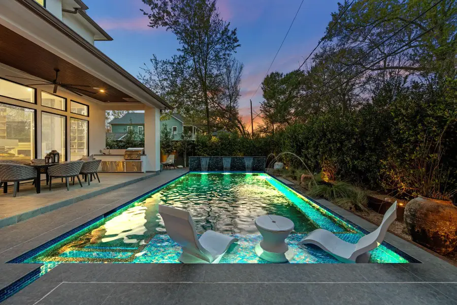Resort-style pool with water features and in-pool loungers—perfect for elevated outdoor living.