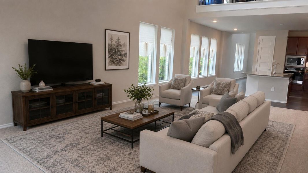 This open-concept living area features a high ceiling and connects directly to the adjacent kitchen space.