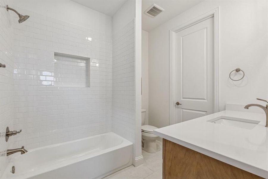 Bathroom featuring vanity,  shower combination, and light tile patterned floors