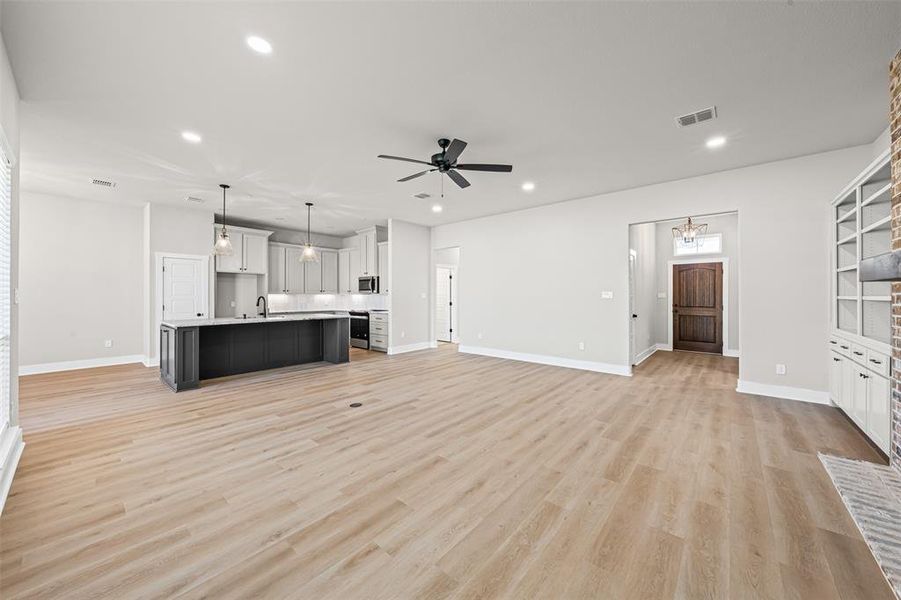 Unfurnished living room featuring a chandelier, recessed lighting, light wood-style floors, and ceiling fan Unfurnished living room featuring a chandelier, recessed lighting, light wood-style floors, and ceiling fan