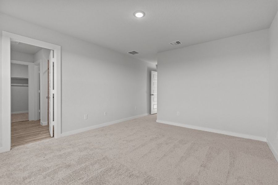 A room with a carpet and a door.
