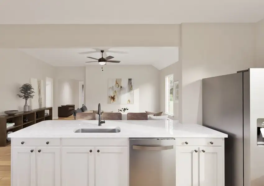 Modern kitchen view with white cabinets and a granite counter facing a cozy living room. Neutral tones, a ceiling fan, and natural light create an airy feel.