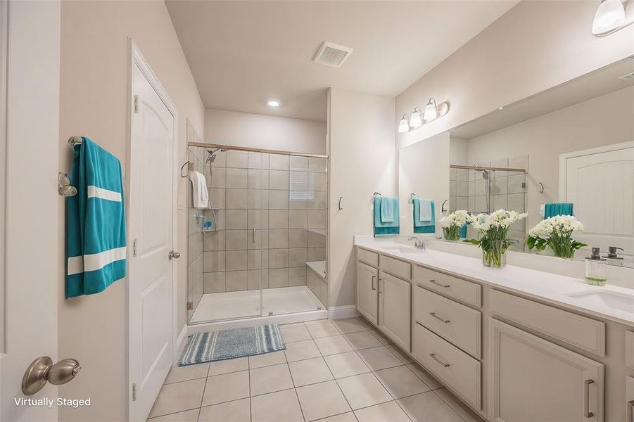 Bathroom featuring tile patterned flooring, vanity, and walk in shower