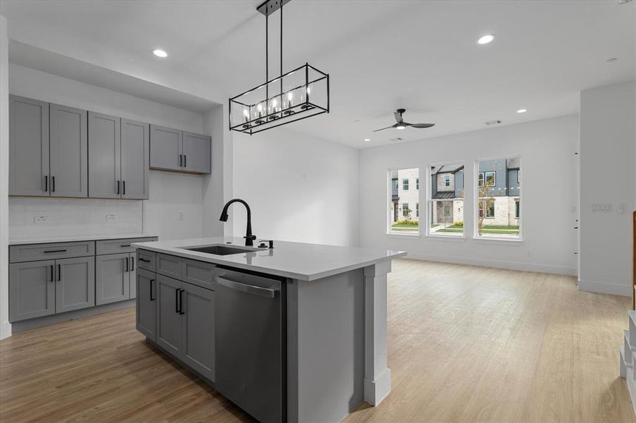 Kitchen with gray cabinets, stainless steel dishwasher, recessed lighting, and light wood-style flooring Kitchen with gray cabinets, stainless steel dishwasher, recessed lighting, and light wood-style flooring