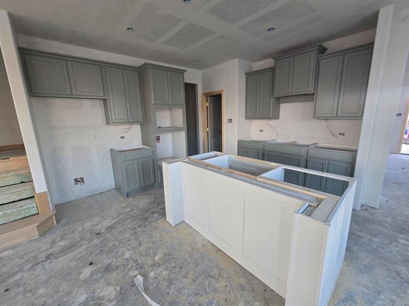 Kitchen featuring gray cabinets, concrete flooring, and a kitchen island