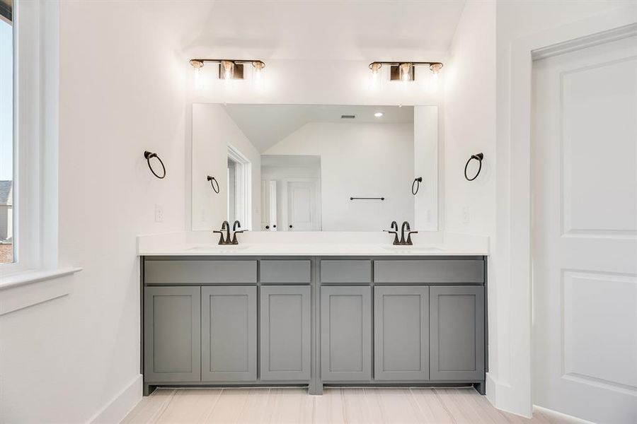 Full bathroom with double vanity and baseboards