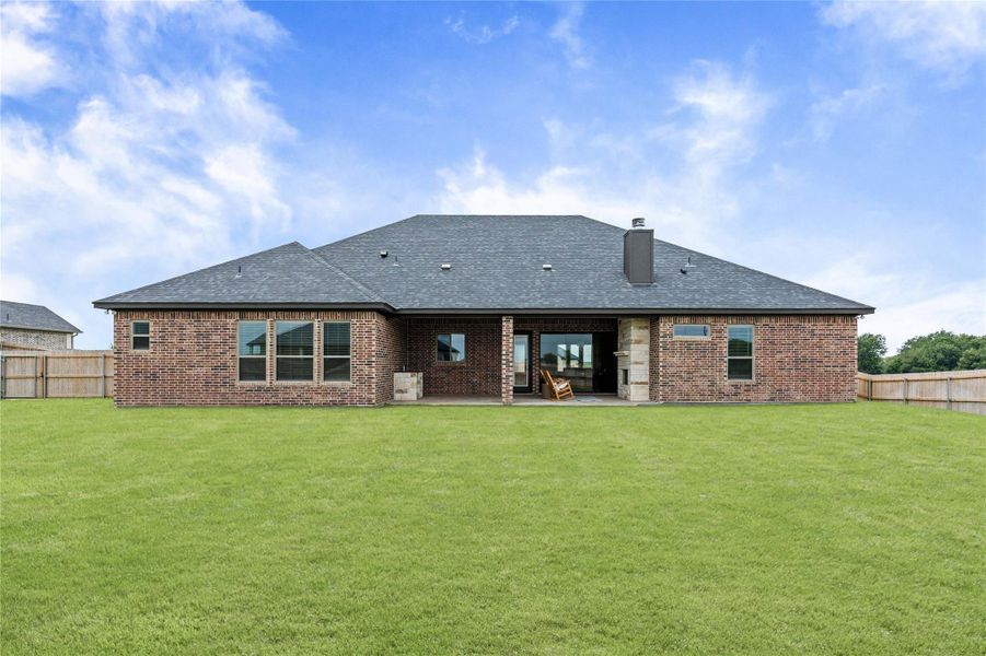 A spacious backyard with a generous lawn and covered patio, perfect for outdoor living. A spacious backyard with a generous lawn and covered patio, perfect for outdoor living.