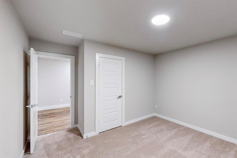 Unfurnished bedroom with light carpet and a closet