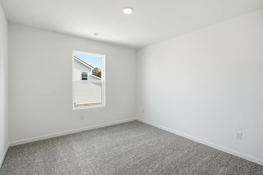 A room with a window and a carpet.