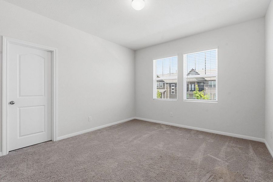 A spacious, naturally illuminated room featuring soft carpeting and a clear view of the surrounding neighborhood. A spacious, naturally illuminated room featuring soft carpeting and a clear view of the surrounding neighborhood.