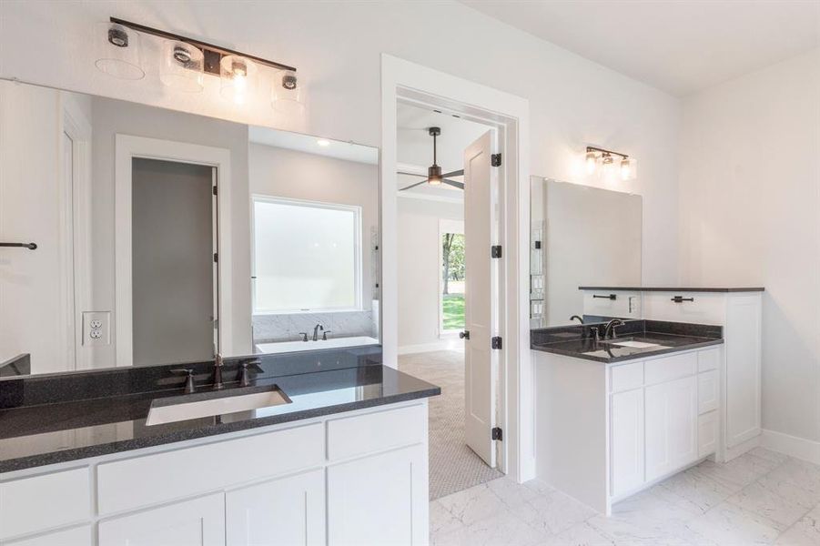 Bathroom featuring ceiling fan, tile patterned flooring, and double vanity