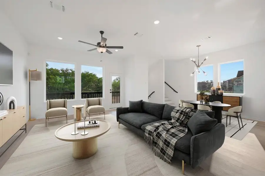 Open-concept living space featuring wood-finish flooring, recessed lighting, and a ceiling fan