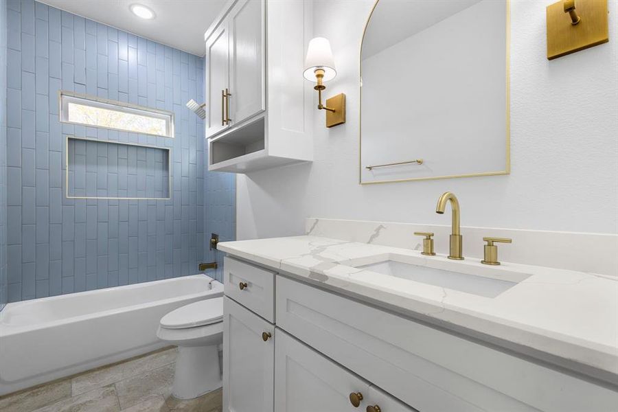 Full bathroom with tiled shower / bath, tile patterned flooring, vanity, and toilet