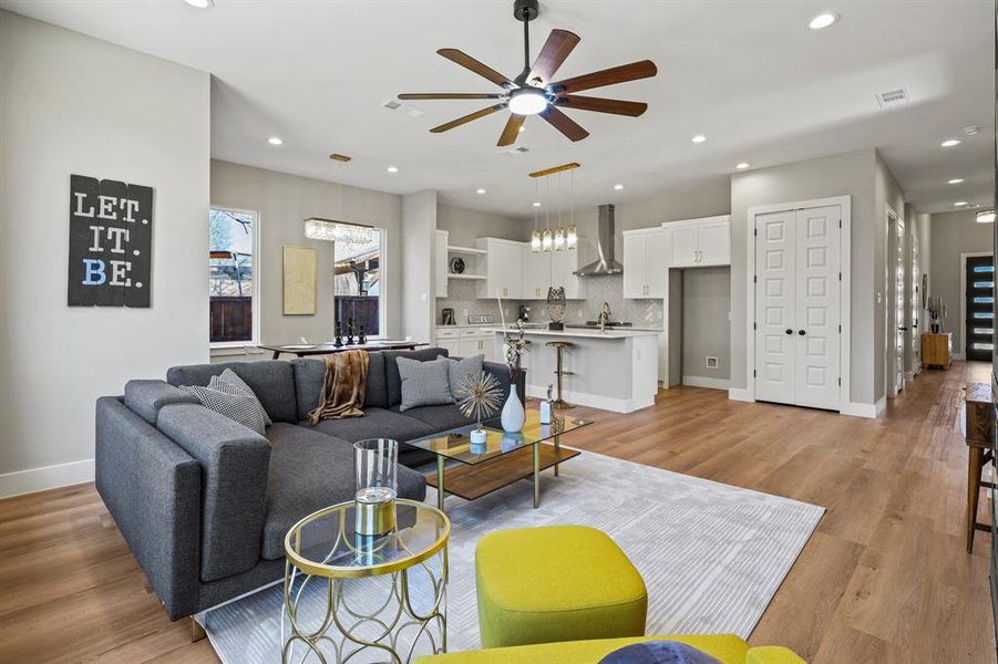 Living room with light wood-style floors, recessed lighting, visible vents, and a ceiling fan