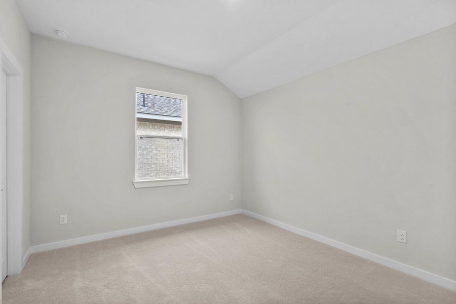 Upstairs bedroom with natural light and carpet.