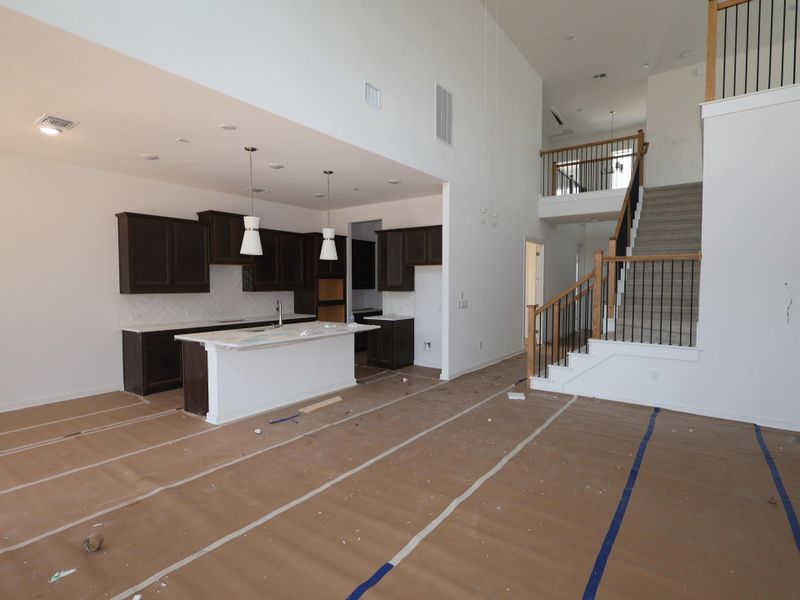 A spacious, airy layout connects the modern kitchen with an inviting living area, complemented by a grand staircase.