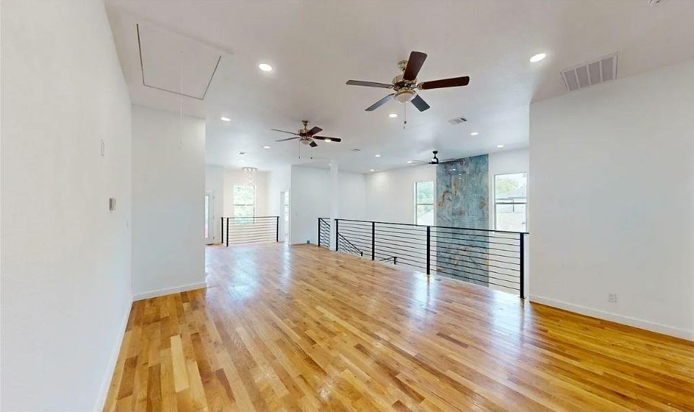 Expansive hardwood flooring with recessed lighting