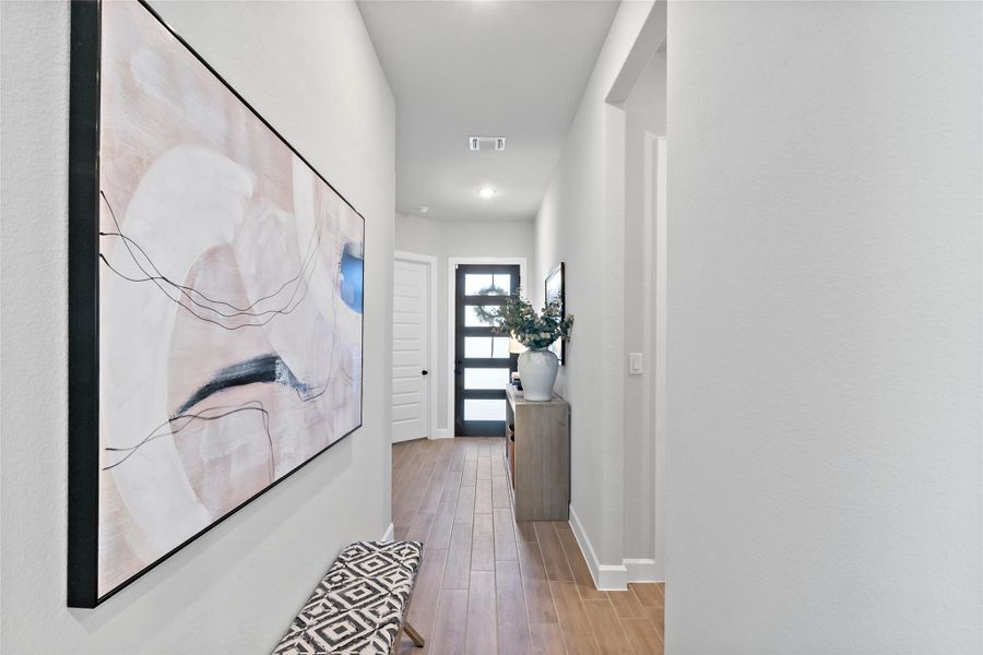 Hallway with light wood-style floors and recessed lighting