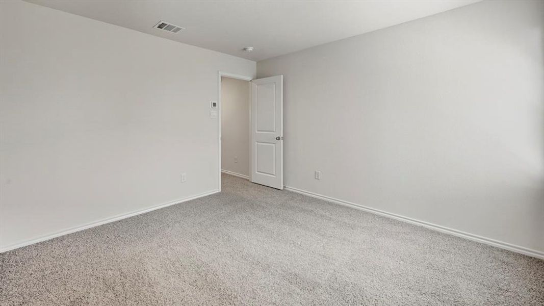 Carpeted spare room featuring baseboards