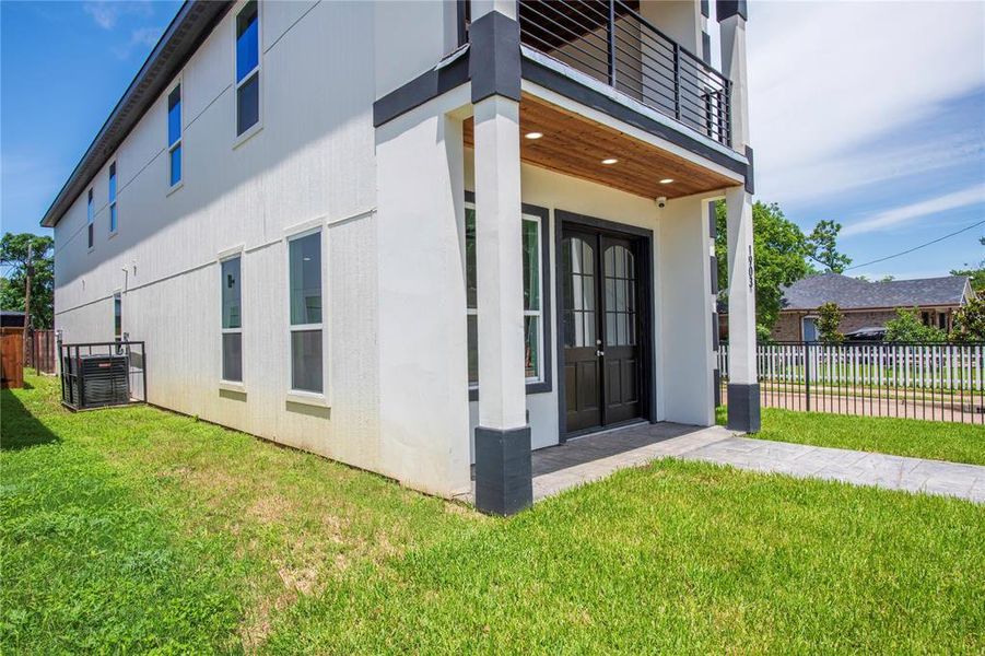 Doorway to property featuring a balcony and a lawn