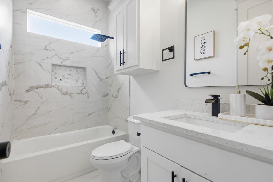 Modern marble tiling elevates this chic bathroom, featuring a sleek vanity and an integrated shower-tub. Modern marble tiling elevates this chic bathroom, featuring a sleek vanity and an integrated shower-tub.