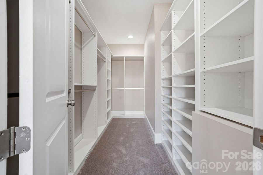 Expansive custom walk-in closet with built-in shelving and ample storage. Expansive custom walk-in closet with built-in shelving and ample storage.
